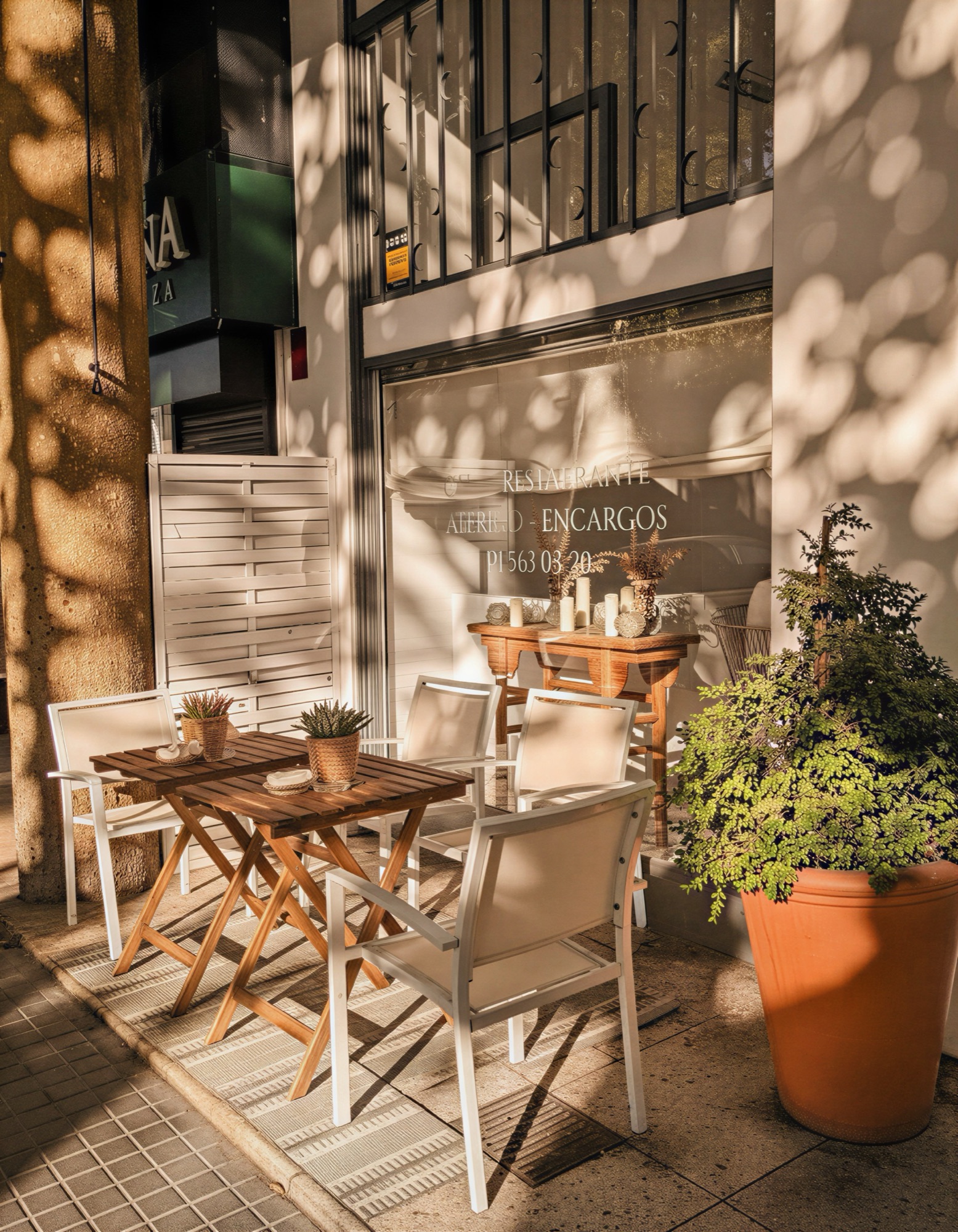 A sunny, dappled café terrace on a Chamartín side street