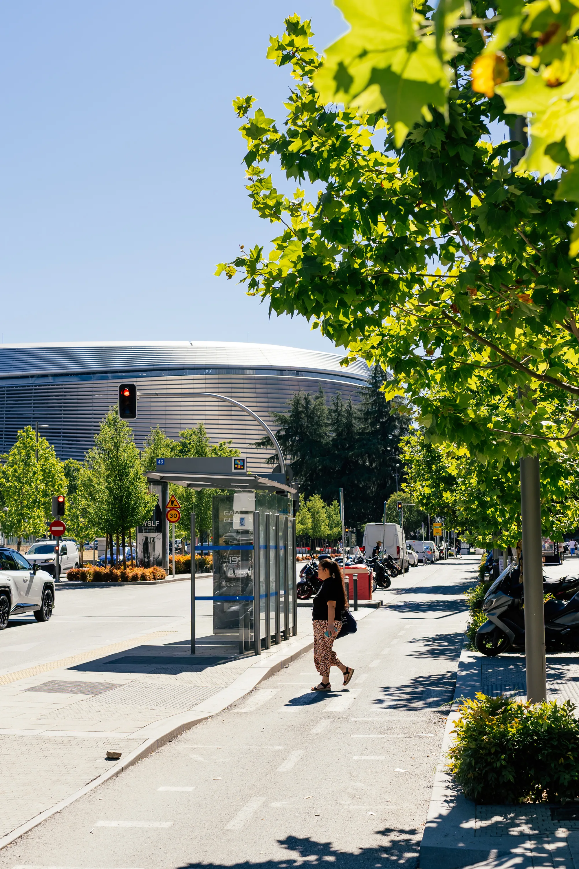 The curved metallic façade of the Santiago Bernabéu stadium glowing at sunset